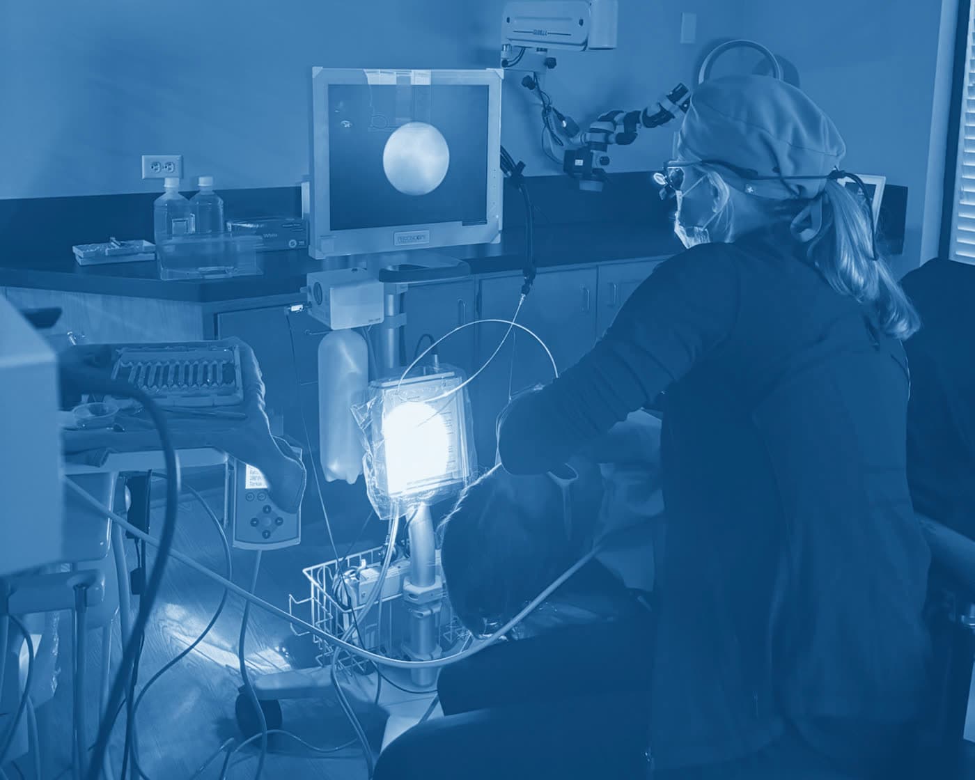 A Perio One clinician using the periodontal endoscope during a deep cleaning, the magnified view on the monitor beside her